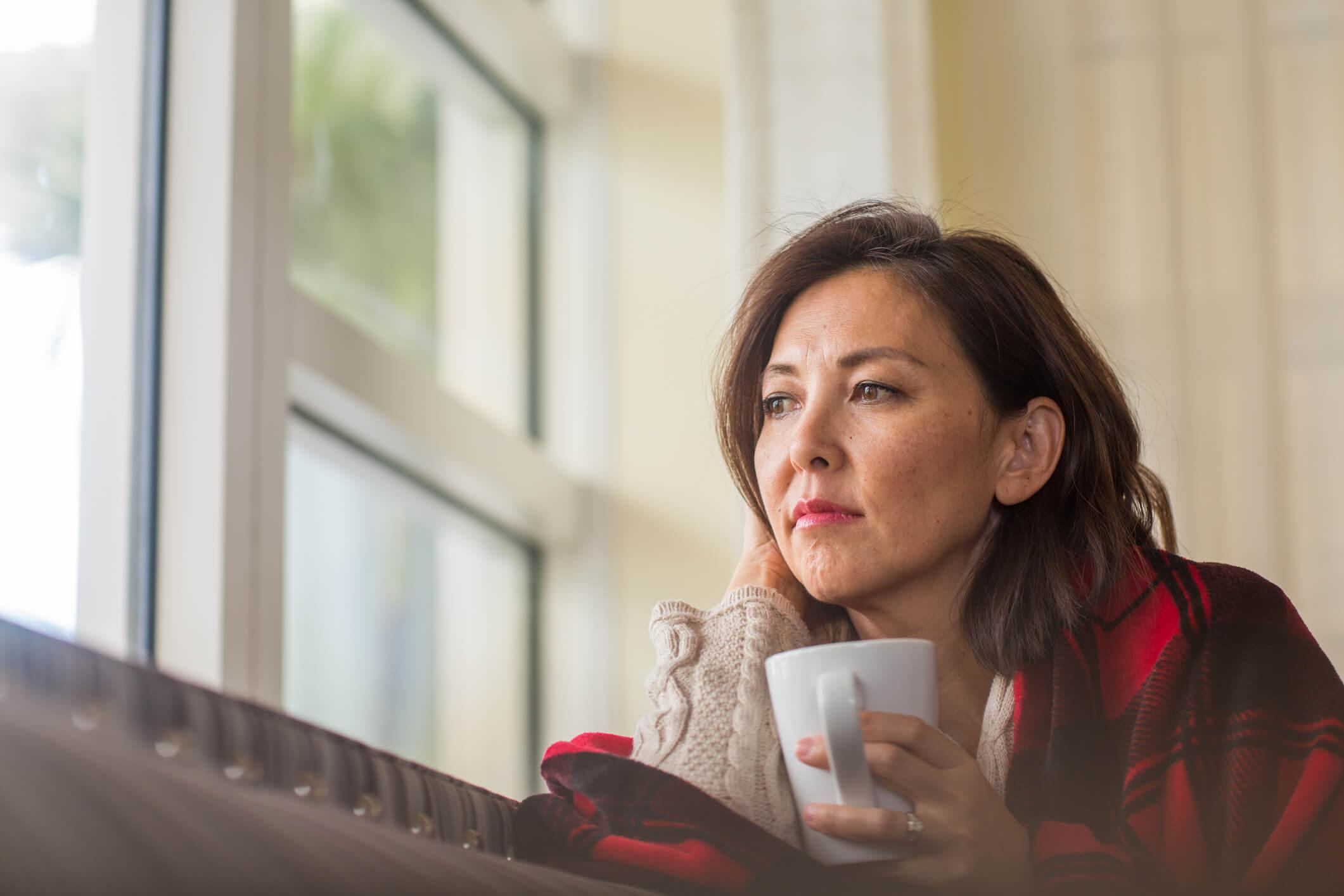 Woman sat alone looking out of a window