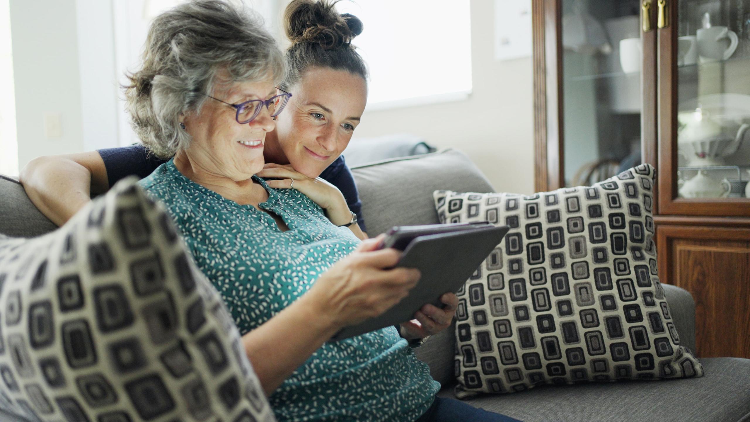 One younger and one older woman looking at tablet device