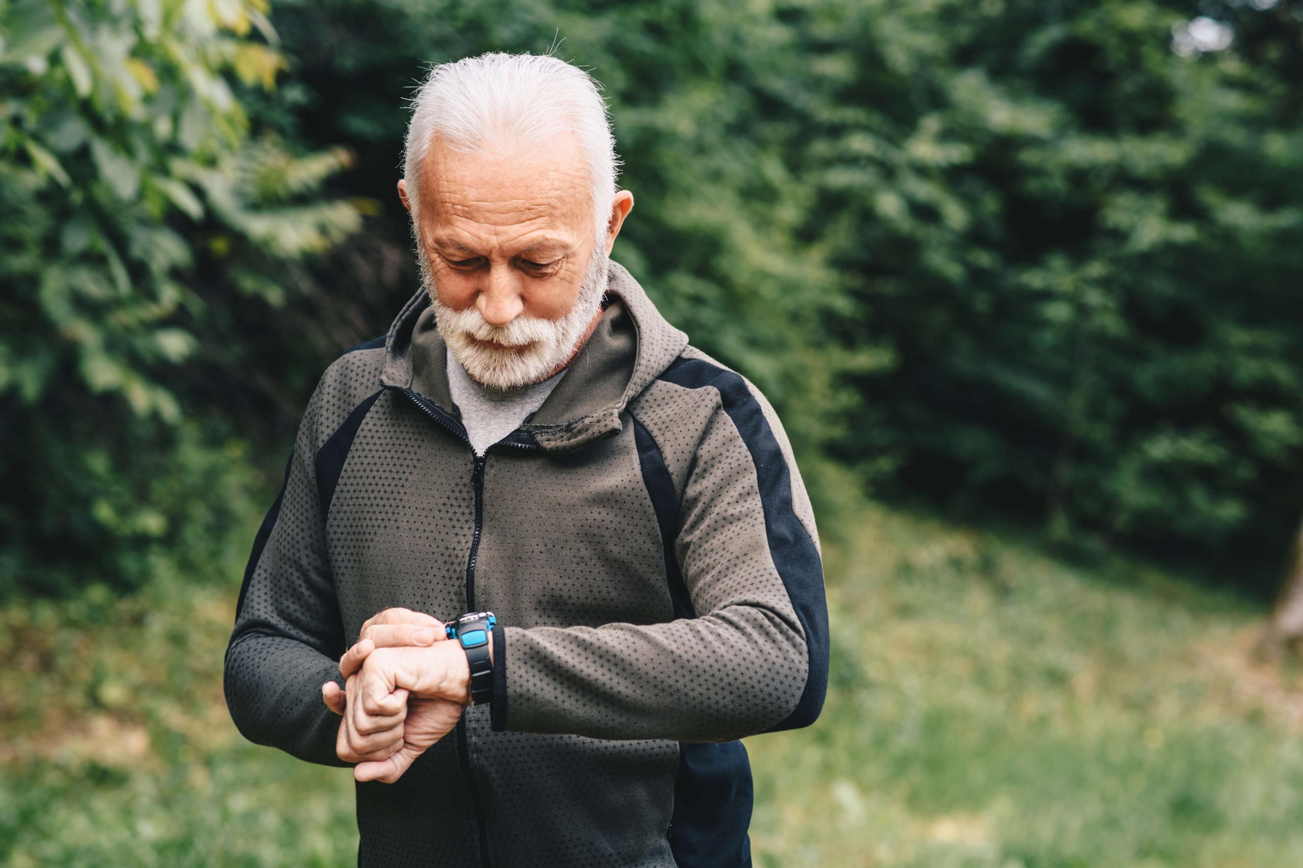 Older man exercising looking at his watch