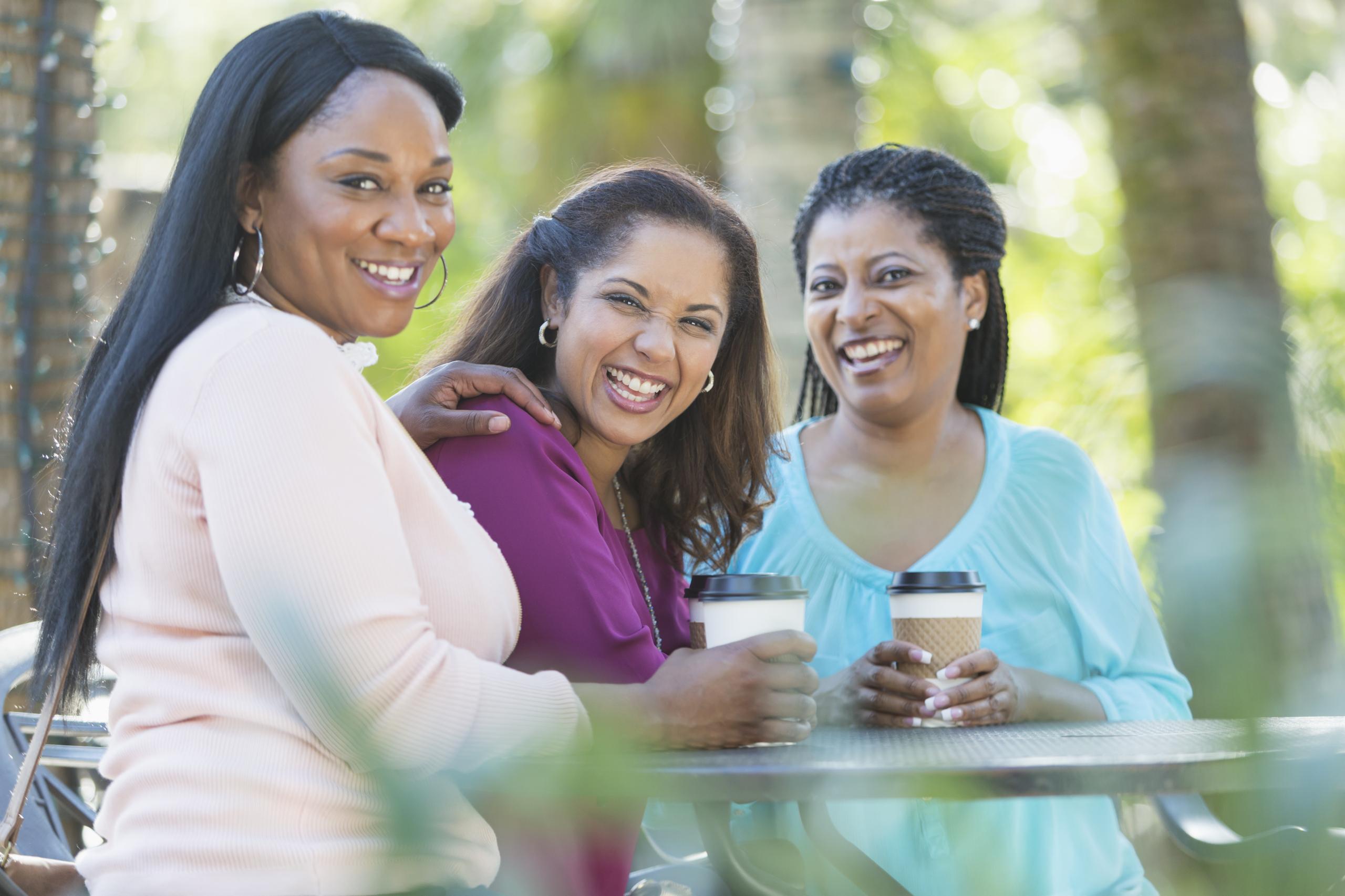 Women chatting outside with a coffee