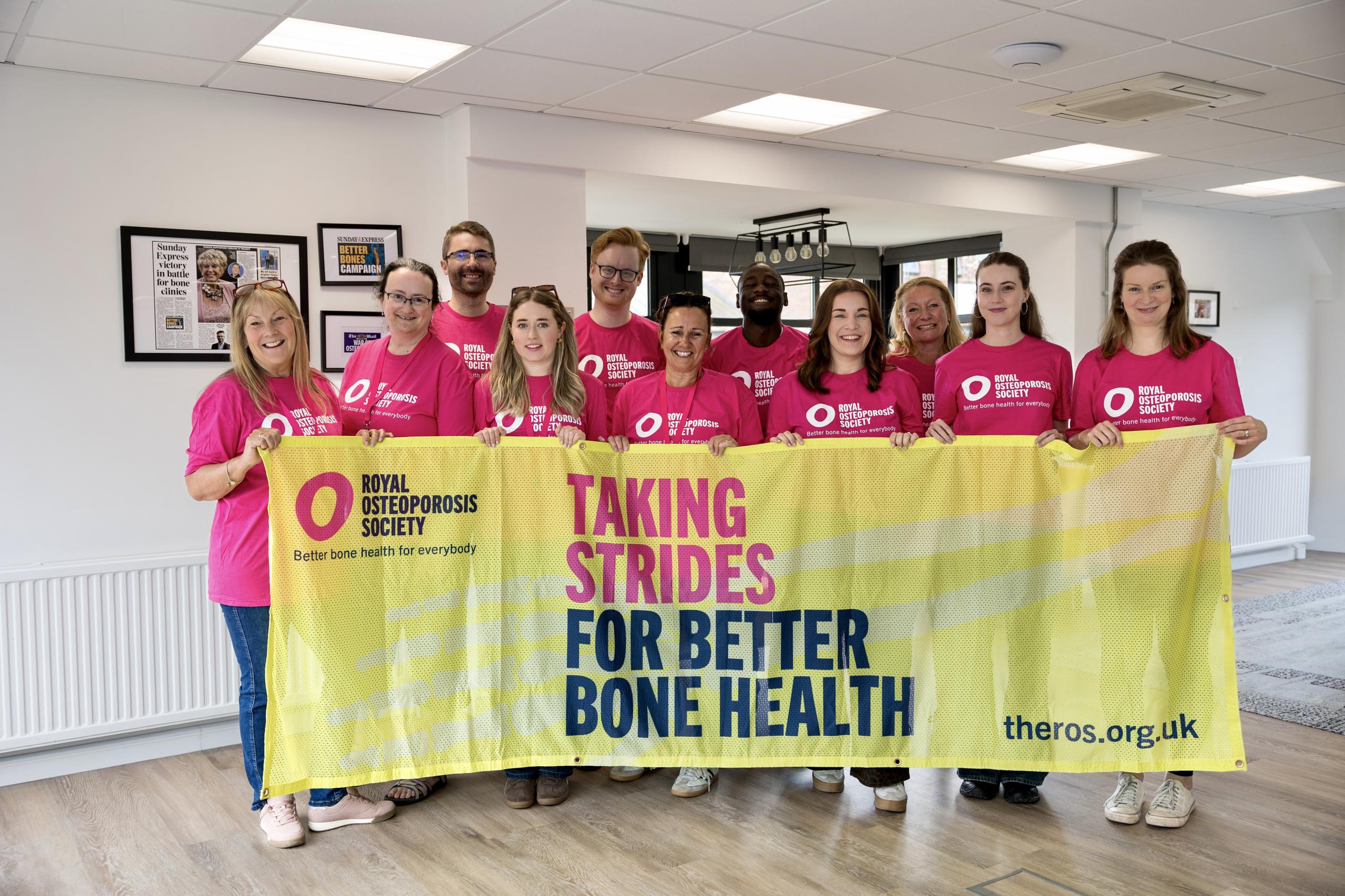 A group of ROS staff standing with a charity banner