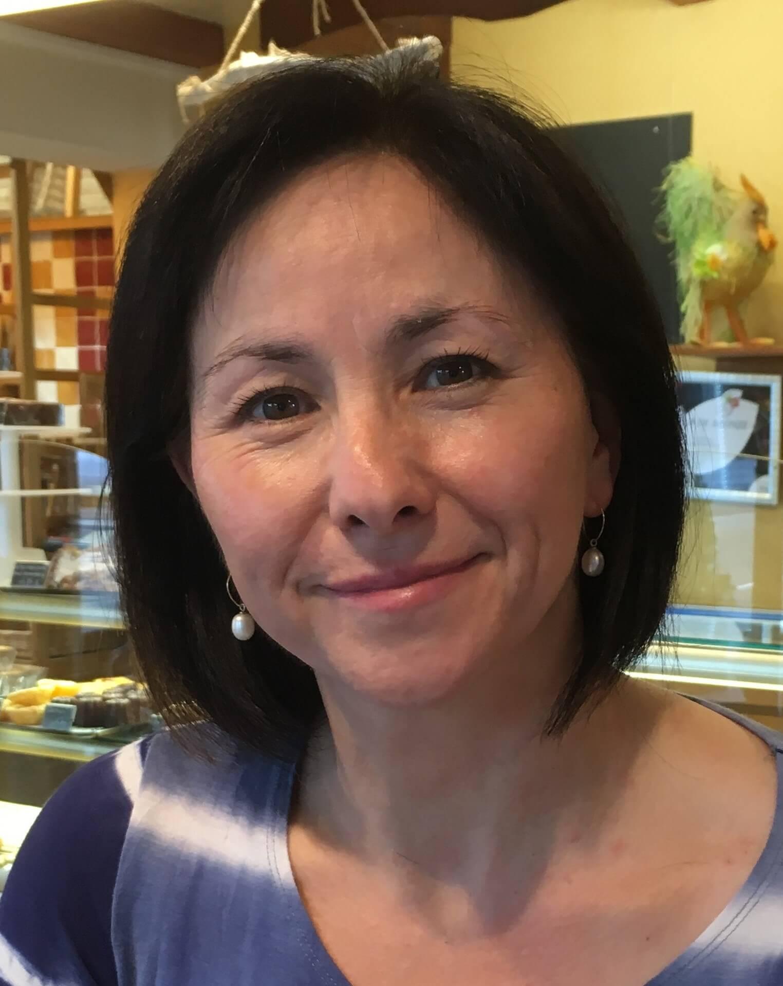 Picture of a lady with dark hair and blue top