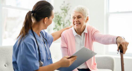 Happy senior woman talking to a healthcare nurse