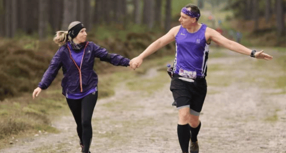 A man running in the woods with his partner