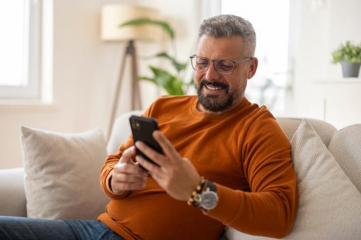 man smiling looking at smartphone 