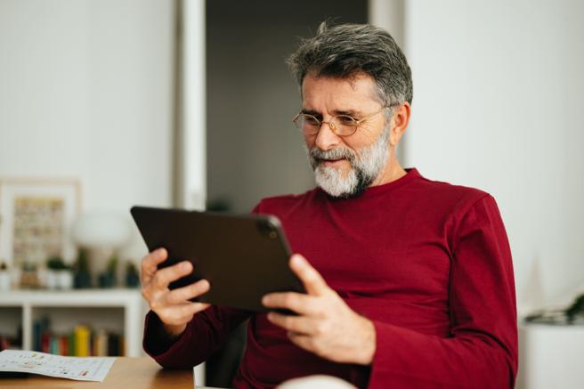 Man sat down using tablet device 