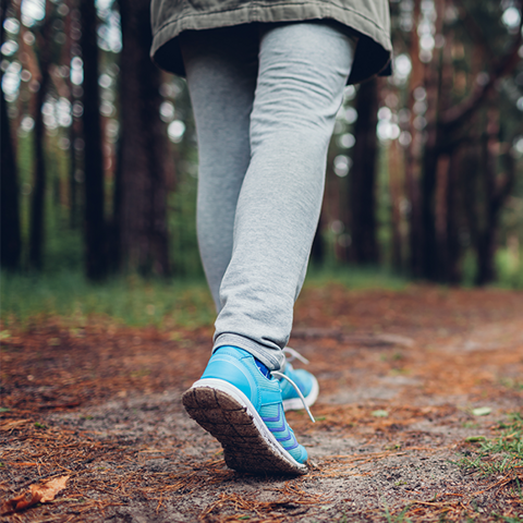 A close up of someone's feet walking in a forest