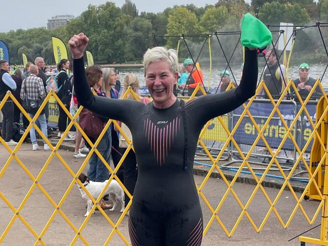 A woman swimmer standing by the Serpentine lake in London