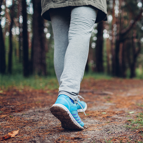 A close up of someone's feet walking in a forest
