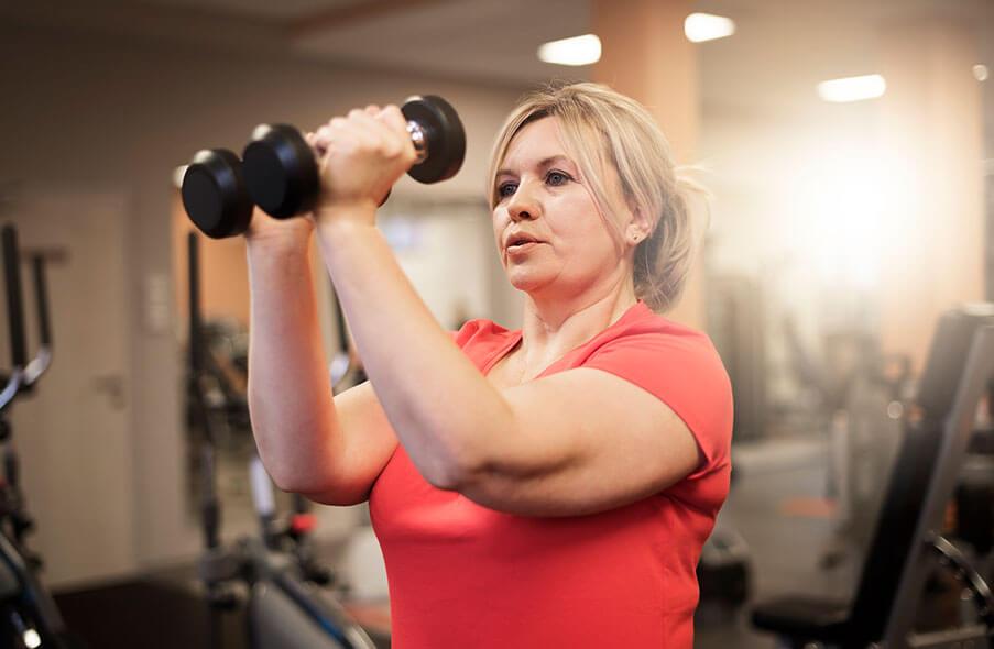A woman using weights in a gym