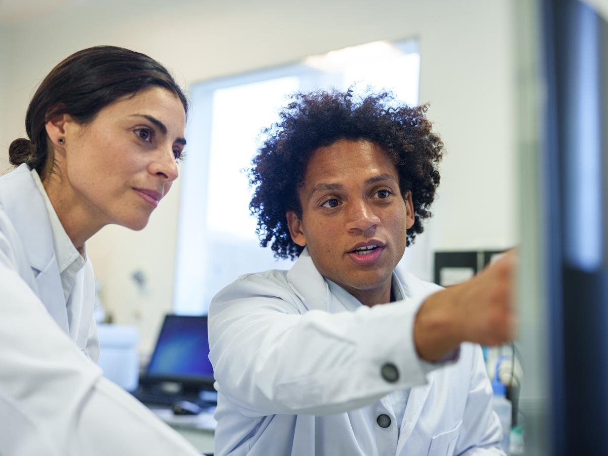 Researchers looking at a computer in a lab