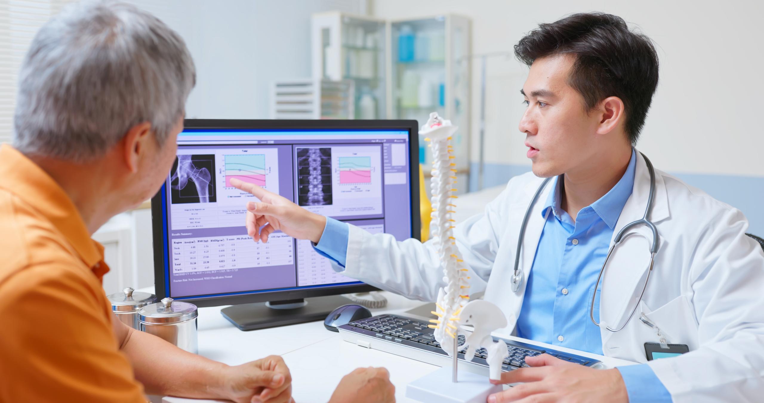 A doctor showing a patient results on a computer