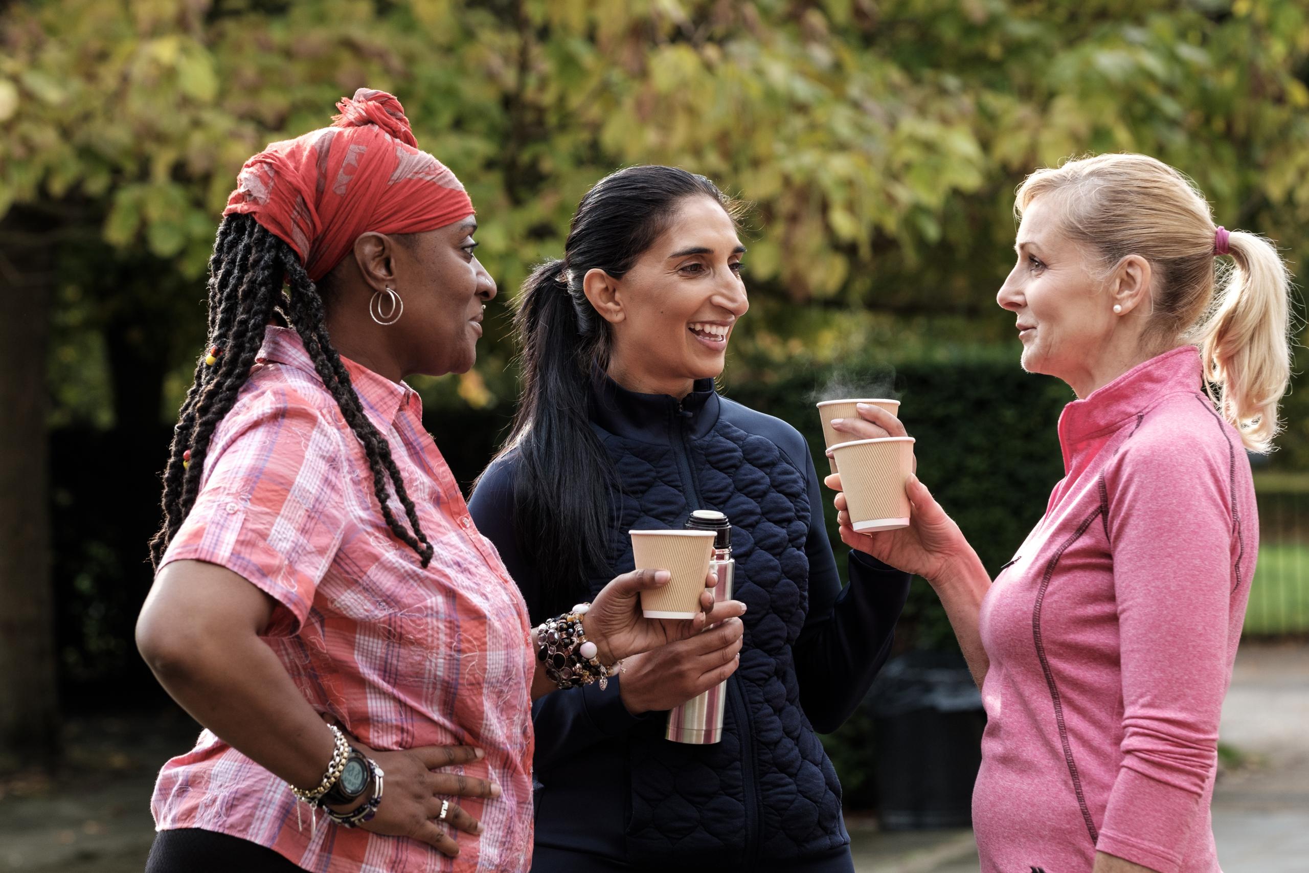 Women chatting outside with coffee