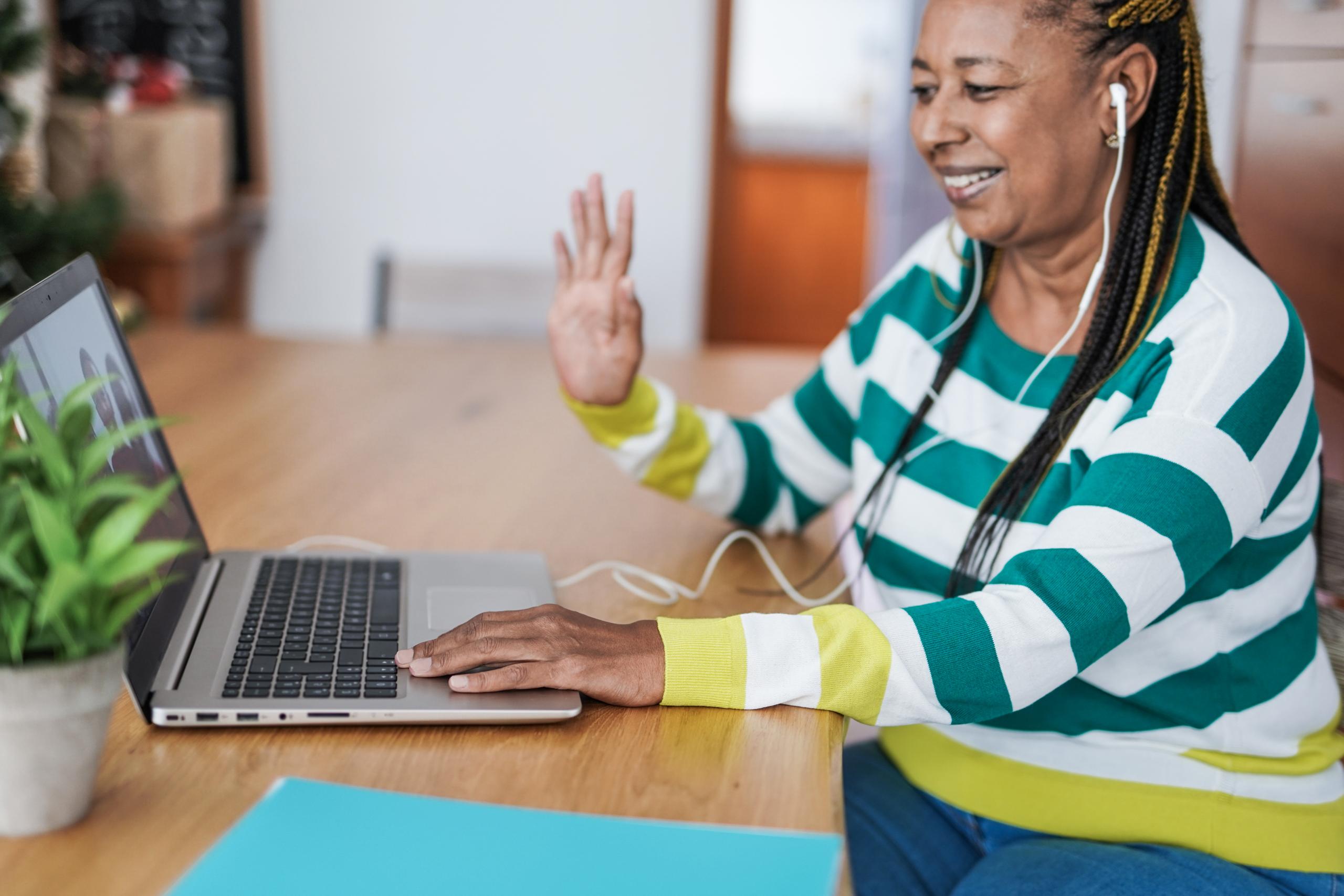 Woman smiling and waving on a video call