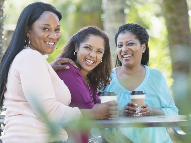 Women chatting outside with a coffee