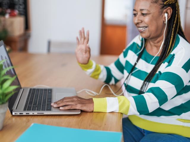 Woman smiling and waving on a video call