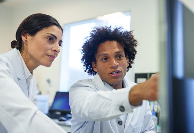Researchers looking at a computer in a lab