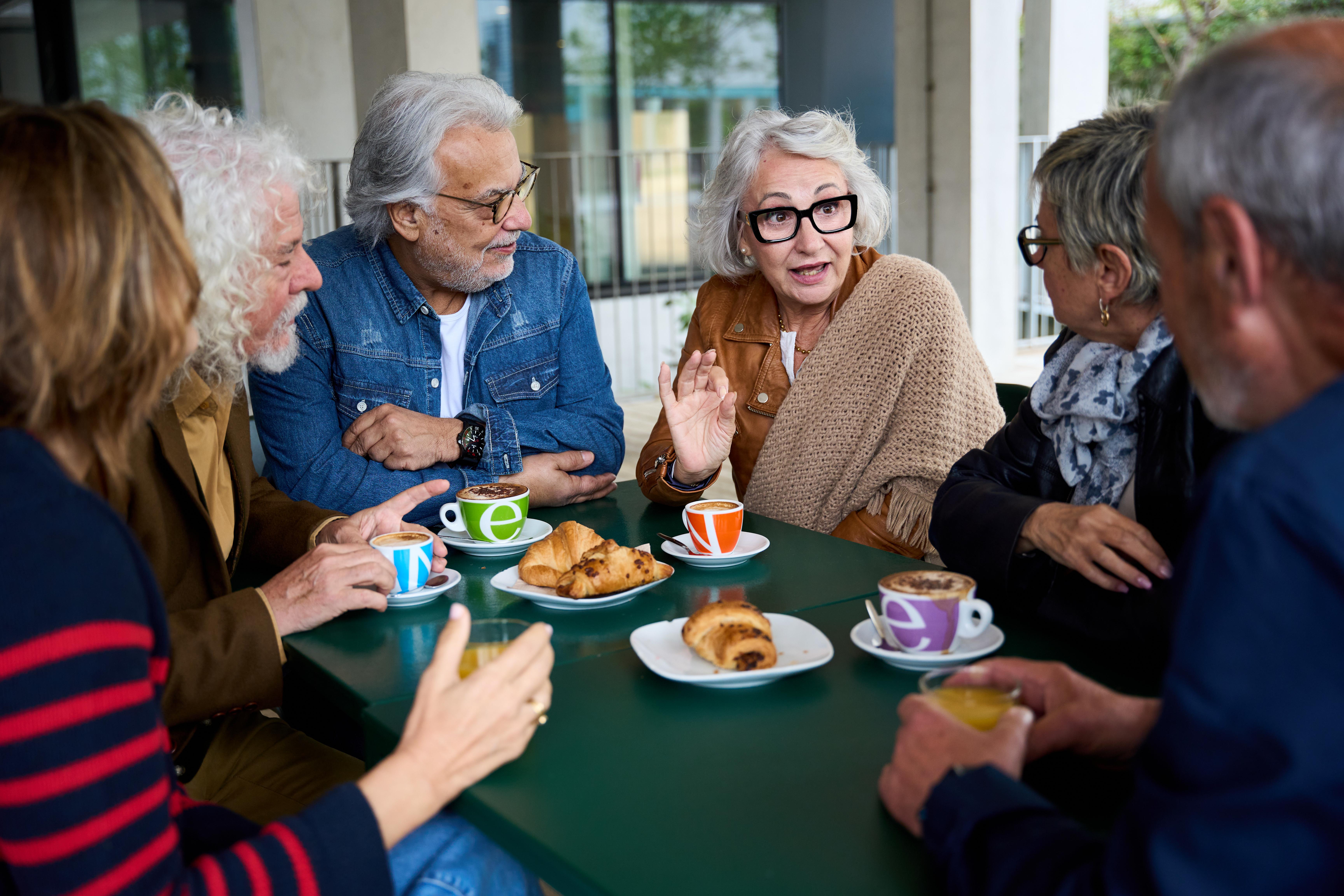 People chatting over tea and pastries